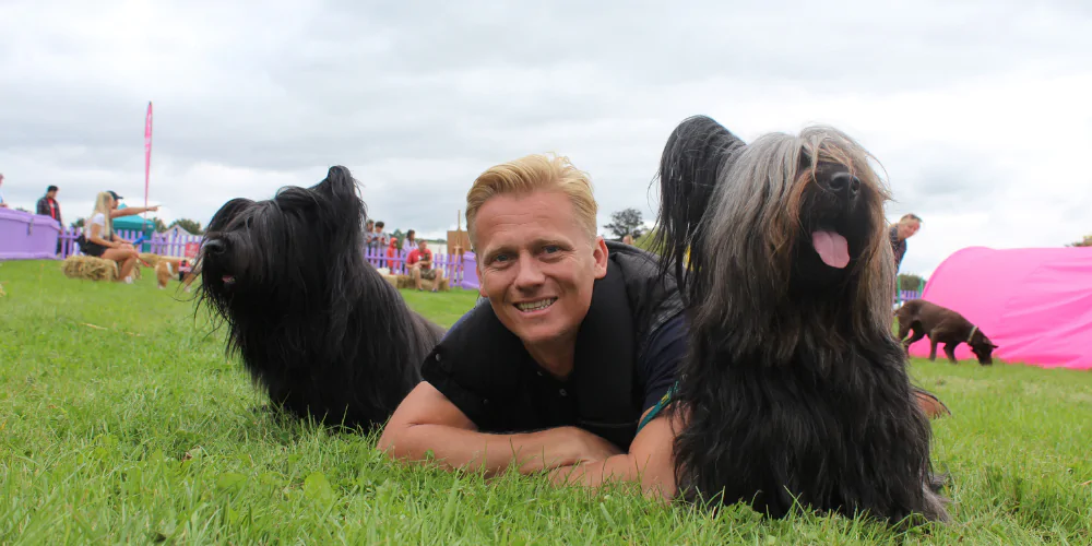 A picture of Dr Scott Miller with two black terriers at The Petsure Games